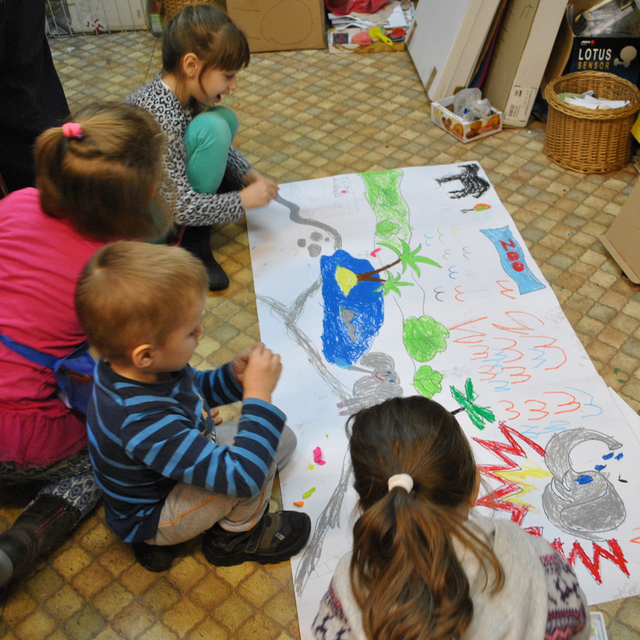 Dzieci malujące wspólnie pracę plastyczną